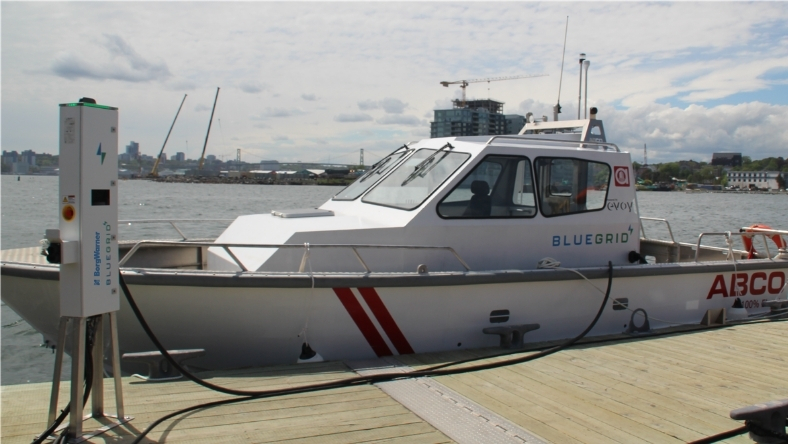 Electric vessel docked and connected to shore power charging station