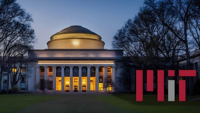 MIT Great Dome illuminated at dusk with MIT logo graphic